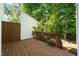 A wooden back deck with brown railing connects to a white building, surrounded by lush trees and foliage at 6051 Epping Forest Dr, Raleigh, NC 27613