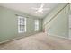 Bedroom with carpet, two windows, and staircase at 6051 Epping Forest Dr, Raleigh, NC 27613