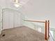A loft area with carpet, a double closet, and railing at 6051 Epping Forest Dr, Raleigh, NC 27613