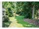 Large backyard with mature trees and a well-maintained lawn at 6205 Remington Lake Dr, Raleigh, NC 27616