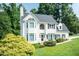 Stately white home with black shutters, mature landscaping, and lush green lawn at 6205 Remington Lake Dr, Raleigh, NC 27616