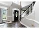 Inviting foyer with a black front door, transom window, and staircase at 6205 Remington Lake Dr, Raleigh, NC 27616
