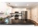Bright kitchen featuring stainless appliances, white cabinets, dark countertops and a large island at 6205 Remington Lake Dr, Raleigh, NC 27616