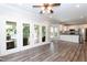 Open-concept living room with hardwood floors and access to the screened porch and kitchen at 6205 Remington Lake Dr, Raleigh, NC 27616