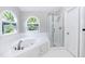Main bathroom features a soaking tub with arched windows and separate shower at 6205 Remington Lake Dr, Raleigh, NC 27616