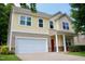 Two-story home showcasing shingle siding, a white garage door, and a cozy front porch area at 642 Collington Dr, Mebane, NC 27302
