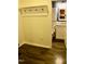 Hallway view leading to bathroom, featuring coat hooks, white trim, and contrasting wall colors at 642 Collington Dr, Mebane, NC 27302