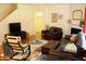 Comfortable living room with hardwood floors, dark leather furniture, fireplace, and stylish geometric area rug at 642 Collington Dr, Mebane, NC 27302