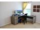 Office space with a gray desk, dual monitors, a chair, yellow curtains, and natural light at 642 Collington Dr, Mebane, NC 27302