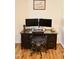 Home office featuring a dark wood desk setup with dual monitors and a comfortable office chair at 642 Collington Dr, Mebane, NC 27302