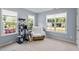 Bright bedroom with neutral walls and carpet and three large windows at 65 Alcock Ln, Youngsville, NC 27596