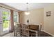 Cozy dining area with hardwood flooring, stylish pendant lighting, and natural light from windows and backyard at 65 Alcock Ln, Youngsville, NC 27596
