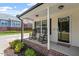 Cozy front porch with rocking chairs, brick accents, and a welcoming entrance with sidelight windows at 65 Alcock Ln, Youngsville, NC 27596
