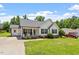 Well-maintained home featuring a lush front lawn, covered porch with rocking chairs, and a private driveway at 65 Alcock Ln, Youngsville, NC 27596