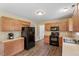 Charming kitchen featuring wood cabinets, black appliances, and wood look flooring at 65 Alcock Ln, Youngsville, NC 27596