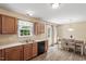 Efficient kitchen and dining area offering stainless sink, black dishwasher, and hardwood-style flooring at 65 Alcock Ln, Youngsville, NC 27596