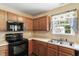 Bright kitchen featuring wood cabinets, neutral countertops and a stainless steel sink at 65 Alcock Ln, Youngsville, NC 27596