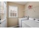 Practical laundry room with a window, a shelf, and a full-sized washer and dryer at 65 Alcock Ln, Youngsville, NC 27596