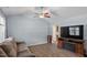 Comfortable living room with stylish hardwood flooring, ceiling fan, and a cozy fireplace entertainment center at 65 Alcock Ln, Youngsville, NC 27596