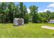 The backyard features a nice sized shed with double doors and lush lawn at 65 Alcock Ln, Youngsville, NC 27596