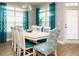 Bright dining room with a white table and chairs complemented by blue curtains and natural light at 67 Blue Spruce Cir, Clayton, NC 27527