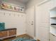 Inviting entryway featuring coat hooks, storage bench, and coastal-inspired artwork at 67 Blue Spruce Cir, Clayton, NC 27527