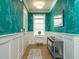 Stylish entryway with teal leaf-patterned wallpaper, white wainscoting, and a modern console table at 67 Blue Spruce Cir, Clayton, NC 27527