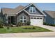 Charming home featuring stone accents, gray siding, a well-manicured lawn, and a two-car garage at 67 Blue Spruce Cir, Clayton, NC 27527