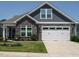 Charming home with stone accents, gray siding, well-manicured lawn, and a two-car white garage at 67 Blue Spruce Cir, Clayton, NC 27527