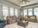 Spacious living room with two sofas, gray leather ottoman, and large windows dressed with patterned curtains at 67 Blue Spruce Cir, Clayton, NC 27527