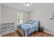 Cozy bedroom featuring hardwood floors, bright natural light, and a comfortable bed at 700 Mossburn Ct, Fuquay Varina, NC 27526