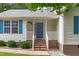 Charming home featuring a covered front porch and freshly painted blue front door and matching shutters at 700 Mossburn Ct, Fuquay Varina, NC 27526
