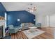 Living room showcasing blue walls, vaulted ceiling, fireplace, and hardwood floors at 700 Mossburn Ct, Fuquay Varina, NC 27526