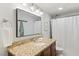 Well-lit bathroom featuring a granite countertop, undermount sink, decorative lighting, and shower with curtain at 7002 Longstreet Dr # C, Raleigh, NC 27615