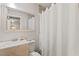 Cozy bathroom featuring a vanity with chrome faucet, framed mirror, and shower with white curtain at 7002 Longstreet Dr # C, Raleigh, NC 27615