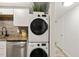 Convenient in-unit laundry area with stacked washer and dryer, next to the modern kitchen with gray countertops at 7002 Longstreet Dr # C, Raleigh, NC 27615