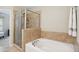 Inviting bathroom featuring a glass shower and a large soaking tub, creating a private oasis for relaxation at 733 Bluffcreek Dr, Fuquay Varina, NC 27526