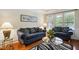 Cozy living room with hardwood floors, sofas, a glass table, and natural light from the window at 733 Bluffcreek Dr, Fuquay Varina, NC 27526