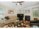 Inviting living room featuring a fireplace, hardwood floors, comfortable seating, and a ceiling fan at 733 Bluffcreek Dr, Fuquay Varina, NC 27526