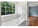 Bright bathroom features a soaking tub with large window and tile surround at 7414 Brandon Allen Ave, Raleigh, NC 27613