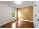 Unstaged bedroom with hardwood floors and a window letting in natural light at 7414 Brandon Allen Ave, Raleigh, NC 27613