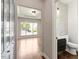 Bright home entryway showcasing an open floor plan and a convenient, stylish half bathroom with patterned wallpaper at 7414 Brandon Allen Ave, Raleigh, NC 27613