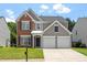 Attractive two-story home with a brick and siding exterior, complemented by a well-maintained front lawn and two-car garage at 7414 Brandon Allen Ave, Raleigh, NC 27613