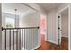 Upstairs hallway with natural light, hardwood floors, and iron railing at 7414 Brandon Allen Ave, Raleigh, NC 27613