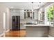Modern kitchen with stainless steel appliances, gray cabinets, hardwood floors, and bright natural light from the window at 7414 Brandon Allen Ave, Raleigh, NC 27613