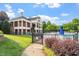 Community pool area with a two story building, lawn area, and an enclosed pool with various chairs and umbrellas at 7414 Brandon Allen Ave, Raleigh, NC 27613