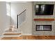 Close-up of staircase with hardwood floors, a modern fireplace, and a bright window illuminating the stairway at 7414 Brandon Allen Ave, Raleigh, NC 27613