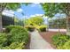 Tennis court with a pathway, lush green foliage, and manicured landscaping creates a welcoming recreational space at 7414 Brandon Allen Ave, Raleigh, NC 27613