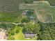 Wide aerial view of the property showcasing the home, surrounding fields, and mature trees at 7595 Clayton Blvd # B, Clayton, NC 27520