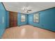 Bedroom with ceiling fan, wood-look floors, and bright blue walls at 7595 Clayton Blvd # B, Clayton, NC 27520